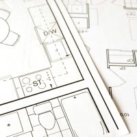 Design, Engineering & Project Management Close-up view of an architectural floor plan on paper showcasing detailed room layouts and measurements.