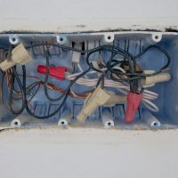 Electrical Services Detailed view of an opened electrical switchboard with visible wires and connectors.